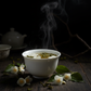 Close-up of fresh jasmine blossoms intertwined with green tea leaves for a smooth, medium-bodied blend